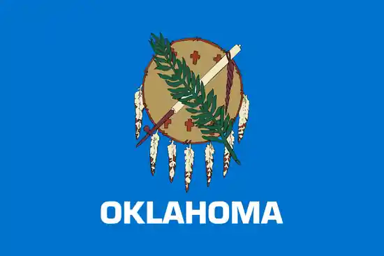 Official Oklahoma state flag with an Osage warrior's shield, peace pipe and olive branch on a sky-blue field above the word Oklahoma.