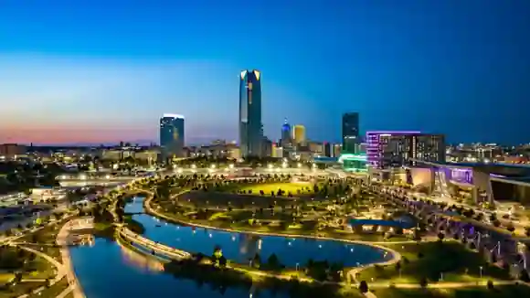 Downtown Oklahoma City skyline at dusk overlooking Scissortail Park, with Devon Tower rising above the city.